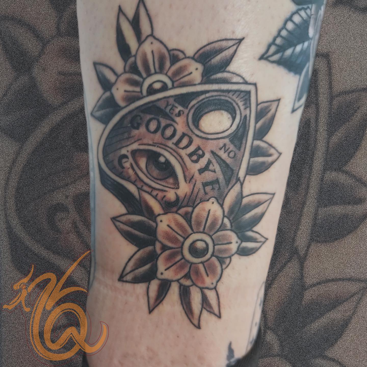 Neo-traditional Ouija planchette with eye and flowers black and grey tattoo