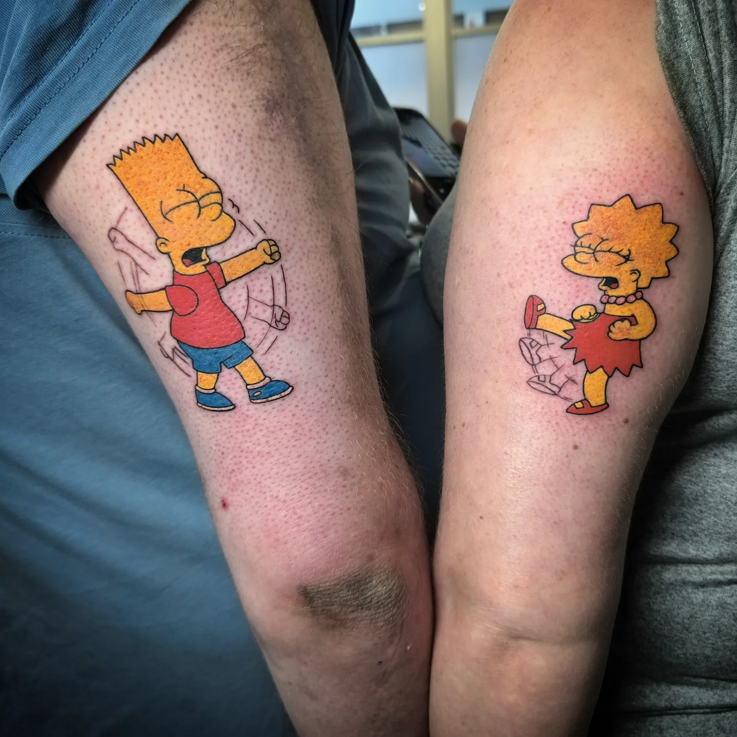 Matching Bart and Lisa Simpsons fighting colour tattoos