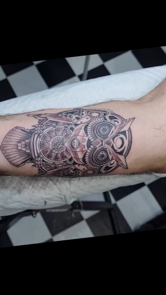 Black and grey steampunk mechanical owl with gears forearm tattoo